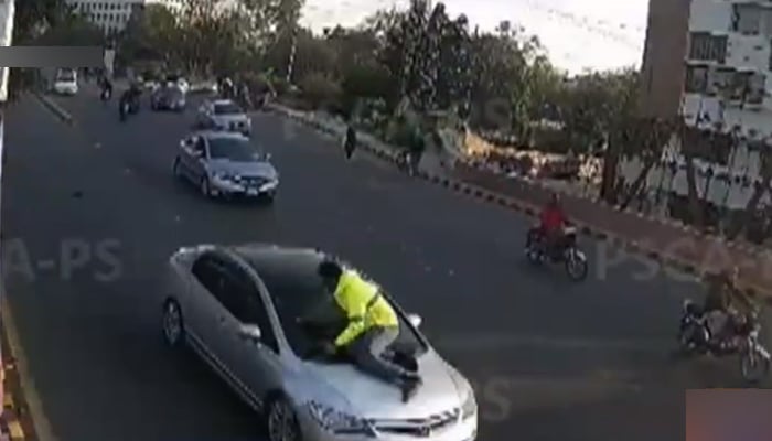 Watch: Lahore man puts traffic warden's life at risk after being asked to pull over