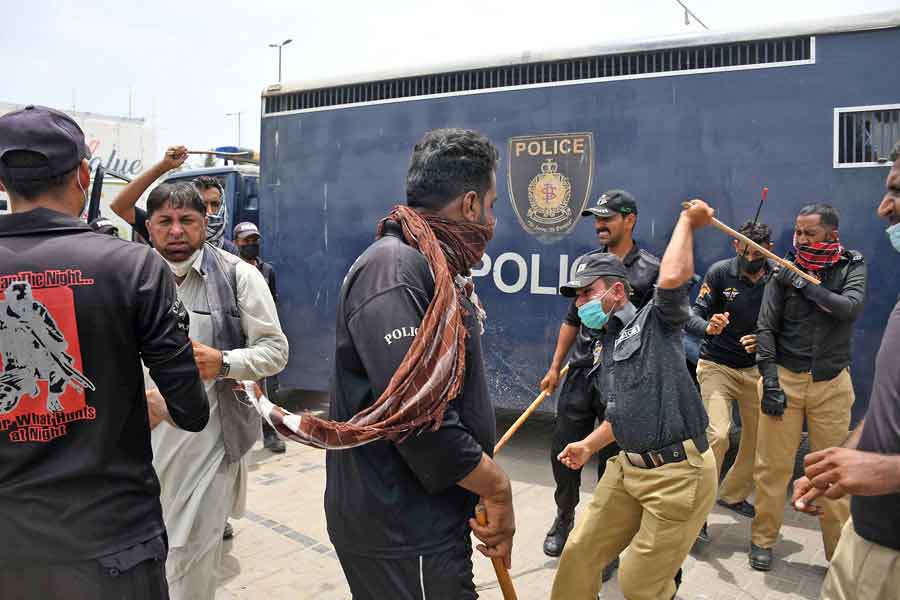 A protester attempts to get away as police personnel charge with batons during a protest against the anti-encroachment operation at Aladdin Park, Gulshan-e-Iqbal, Karachi, on June 15, 2021. — Online photo by Sabir Mazhar