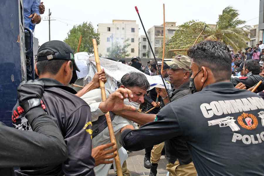 A man bears the brunt of the polices baton charge, during a protest against the anti-encroachment operation at Aladdin Park, Gulshan-e-Iqbal, Karachi, on June 15, 2021. — Online photo by Sabir Mazhar