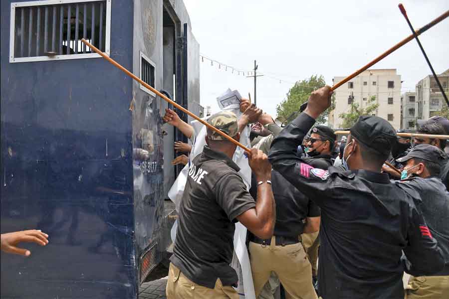 Police personnel charging with batons at protesters to disperse them and continue the anti-encroachment operation at Aladdin Park, Gulshan-e-Iqbal, Karachi, on June 15, 2021. — Online photo by Sabir Mazhar