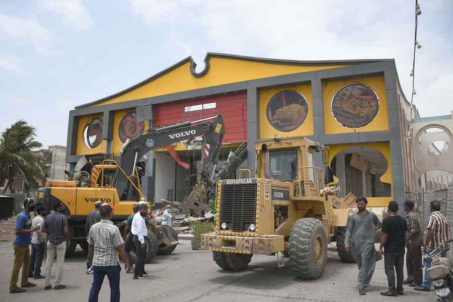 The restaurant sign being taken down, during the the anti-encroachment operation at Aladdin Park, Gulshan-e-Iqbal, Karachi, on June 15, 2021. — Online photo by Sabir Mazhar