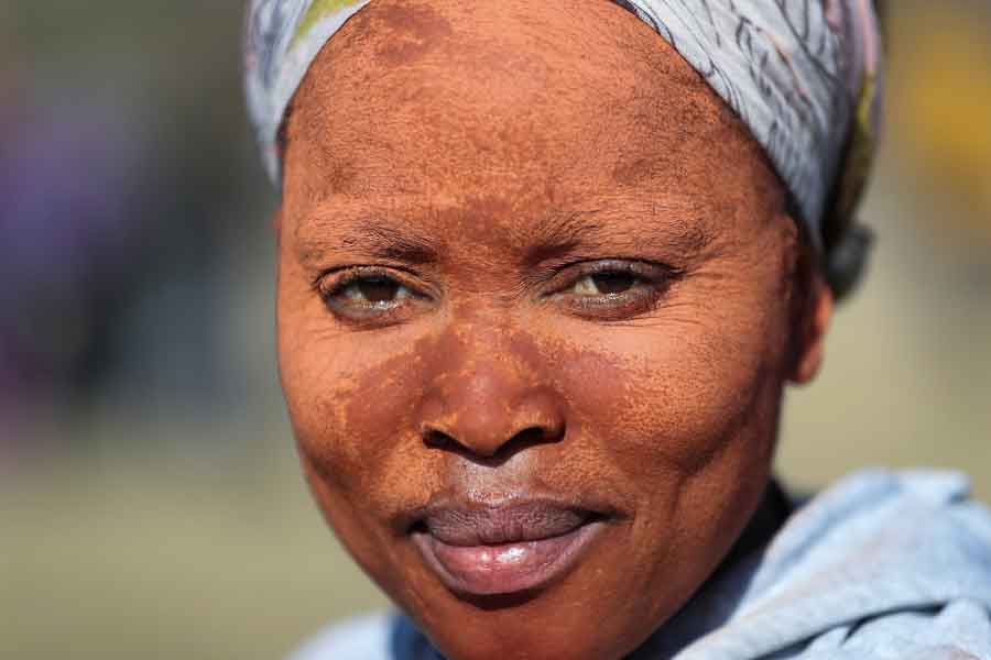 A woman using clay to apply on her face to protect her skin from the sun looks on as fortune seekers flock to the village after pictures and videos were shared on social media showing people celebrating after finding what they believe to be diamonds, in the village of KwaHlathi outside Ladysmith, in KwaZulu-Natal province, South Africa, June 14, 2021. — Reuters/Siphiwe Sibeko