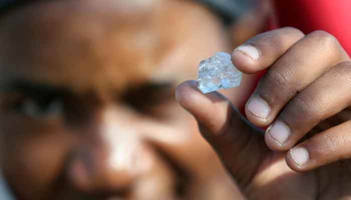 A man shows an unidentified stone as fortune seekers flock to the village after pictures and videos were shared on social media showing people celebrating after finding what they believe to be diamonds, in the village of KwaHlathi outside Ladysmith, in KwaZulu-Natal province, South Africa, June 14, 2021. — Reuters/Siphiwe Sibeko