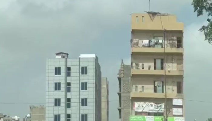 A picture of the building on the right dangerously tilting in one direction, in Karachis DHA. Photo: File