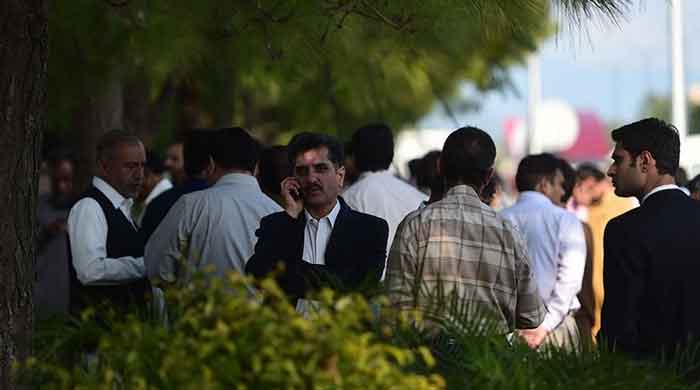Federal government employees gather outside their offices after an earthquake in Islamabad, in this undated AFP file photo.