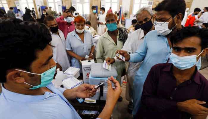 Residents with their registration cards gather at a counter to receive a dose of a COVID-19 vaccine, at a vaccination centre in Karachi, June 9, 2021. — Reuters/Akhtar Soomro