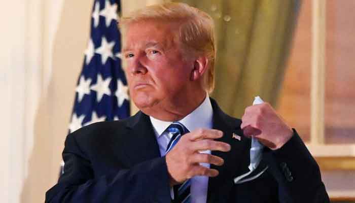 US President Donald Trump pulls off his protective face mask as he poses atop the Truman Balcony of the White House after returning from being hospitalized at Walter Reed Medical Center for coronavirus disease (COVID-19) treatment, in Washington, US October 5, 2020. — Reuters/Erin Scott