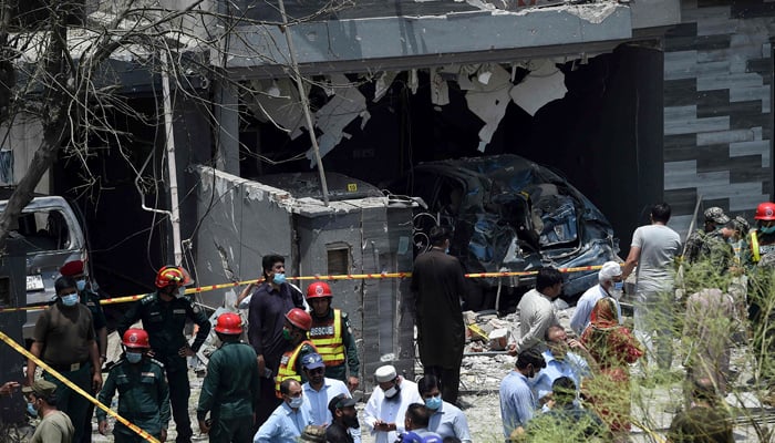 Security officials inspect the site of an explosion that killed at least three people and wounded several others in Lahore on June 23, 2021. — AFP