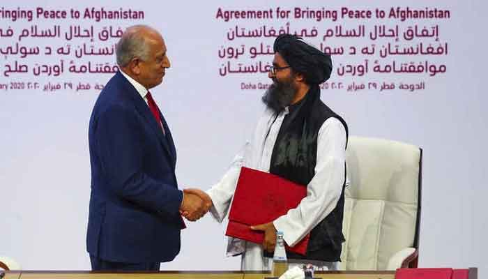 US special envoy Zalmay Khalilzad shakes hands with the head of the Talibans political office, Mullah Abdul Ghani Baradar, ahead of a peace conference in Doha, in this 2020 Reuters file photo.