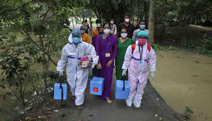 Healthcare workers carry COVISHIELD vaccine, a coronavirus disease (COVID-19) vaccine manufactured by Serum Institute of India, to inoculate villagers during a door-to-door vaccination and testing drive at Uttar Batora Island in Howrah district in West Bengal state, India, June 21, 2021. — Reuters/Rupak De Chowdhuri