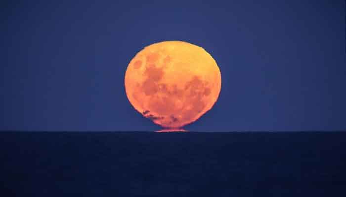 The strawberry moon rises over the ocean on Narrawallee Beach in New South Wales, Australia, on June 6, 2020. — David Gray/AFP