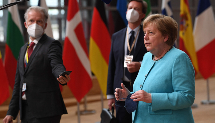 Germanys Chancellor Angela Merkel (R) gestures as she addresses media representatives as she arrives on the first day of a European Union (EU) summit at The European Council Building in Brussels on June 24, 2021. — AFP