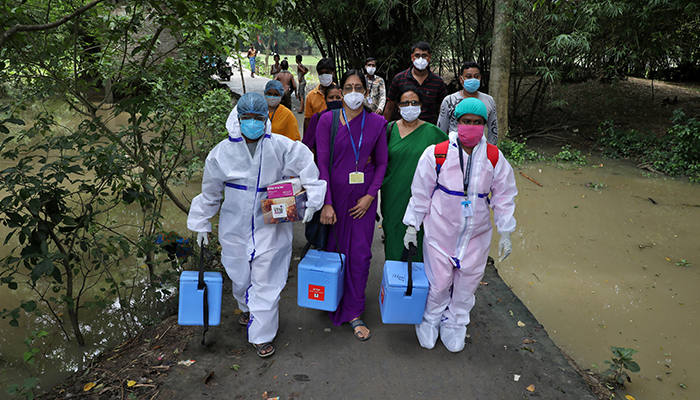 Healthcare workers carry COVISHIELD vaccine, a coronavirus disease (COVID-19) vaccine manufactured by Serum Institute of India, to inoculate villagers during a door-to-door vaccination and testing drive at Uttar Batora Island in Howrah district in West Bengal state, India, June 21, 2021. — Reuters/File