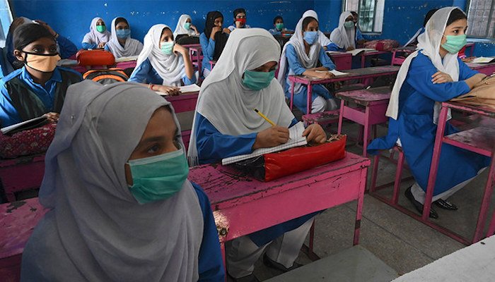 Female students wearing masks, listen attentively to a lecture. Photo: File