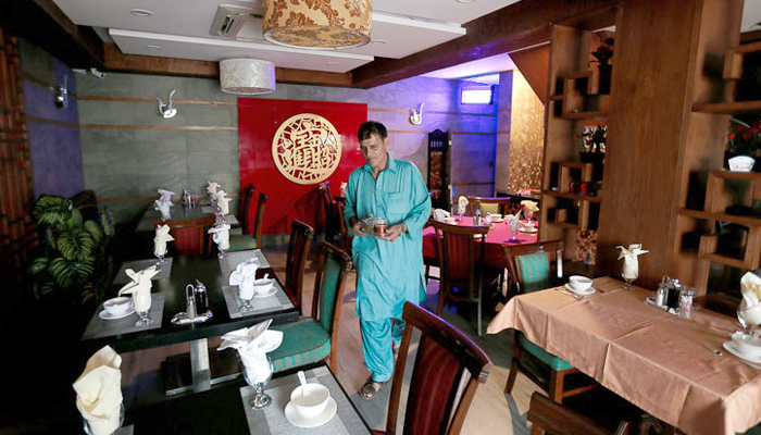 A waiter prepares tables at a Chinese restaurant catering to the growing Chinese population in Islamabad. — Reuters/File