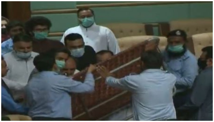 Image showing PTI lawmakers holding a charpoy inside the Sindh Assembly on Monday, June 28. Photo: Screengrab via Geo News.