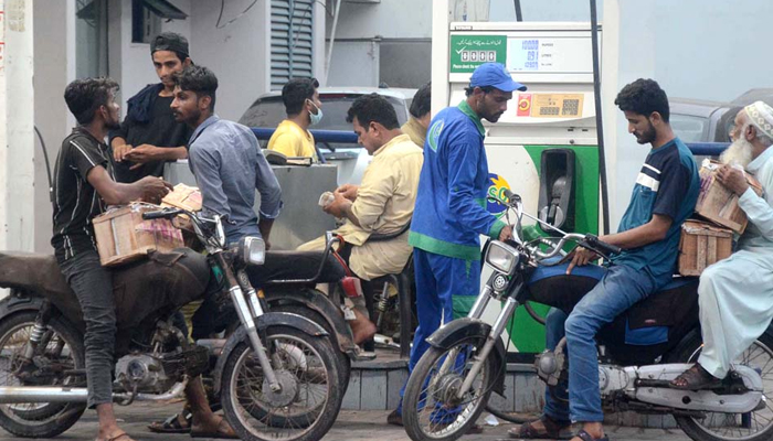People getting their fuel tanks filled with petrol at a gas pump in Karachi, on May 28, 2021. — APP/File