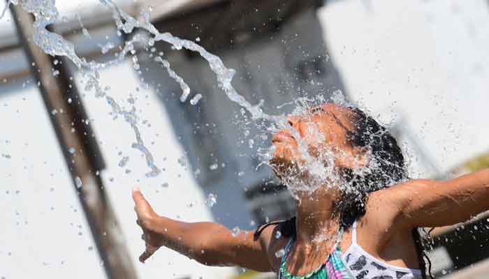 A kid cools off at a community water park on a scorching hot day in Richmond, British Columbia, June 29, 2021. — AFP