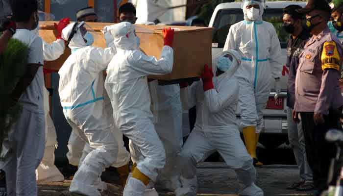 Local disaster mitigation agency personnel in personal protective equipment (PPE) carry the coffin of a person who passed away due to coronavirus disease (COVID-19) during a funeral in Tegal, Central Java province, Indonesia, June 30, 2021, in this photo taken by Antara Foto .&mdash; AFP