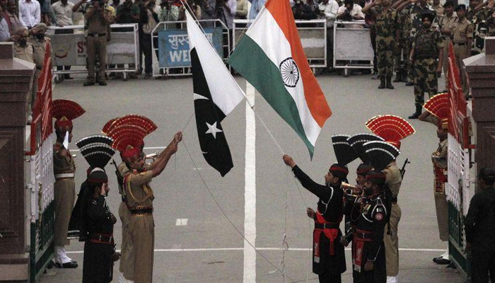 Pakistani rangers (wearing black uniforms) and Indian Border Security Force (BSF) officers lower their national flags during a daily parade at the Pakistan-India joint check-post at Wagah border, near Lahore November 3, 2014. — Reuters/File