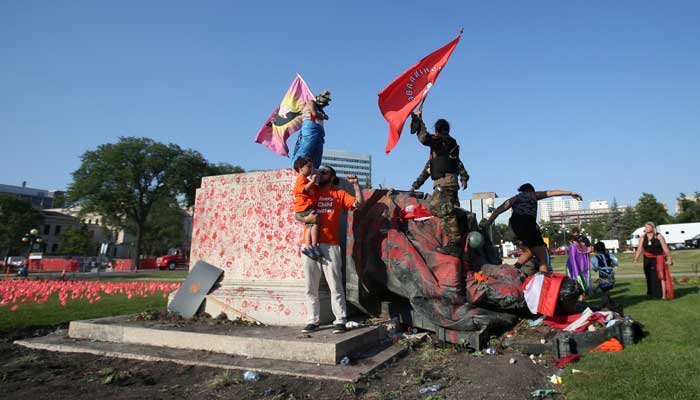 A defaced statue of Queen Victoria lies after being toppled during a rally, following the discovery of the remains of hundreds of children at former indigenous residential schools, outside the provincial legislature on Canada Day in Winnipeg, Manitoba, Canada July 1, 2021. -REUTERS