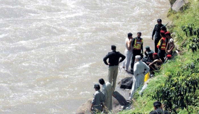 Rescue personnel can be seen standing by a river in this file photo.