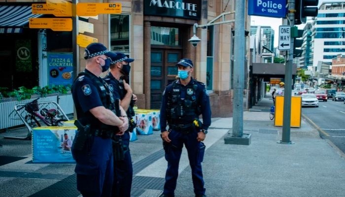Police officers wearing masks pictured standing by a street in Australia. Photo: AFP