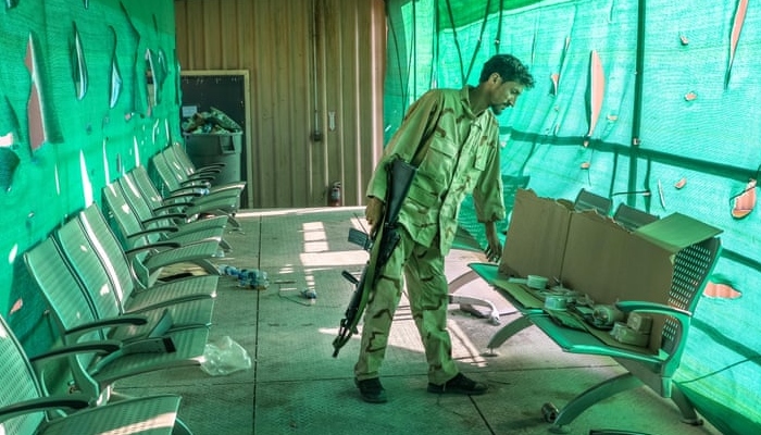 An Afghan soldier surveys belongings left by the US military. Afghan troops were critical of how the US left Bagram, going in the night without telling the Afghan soldiers patrolling the perimeter. Photo: EPA