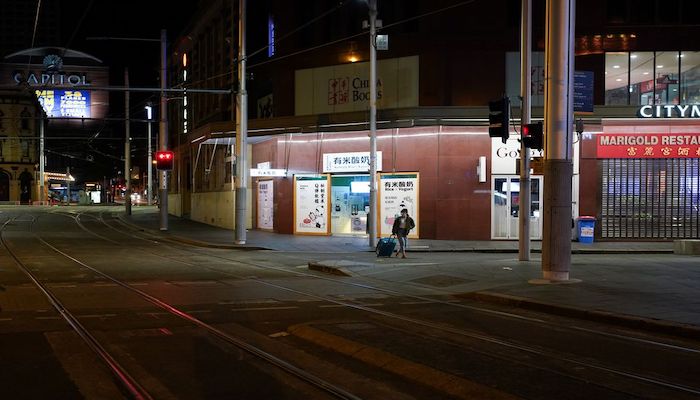 A lone woman wearing a protective face mask pulls a suitcase through the city centre during a lockdown to curb the spread of a coronavirus disease (COVID-19) outbreak in Sydney, Australia, July 6, 2021. Photo: Reuters