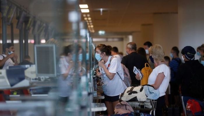 People queue at check in desks at Faro airport amid the coronavirus disease (COVID-19) pandemic, in Faro, Portugal, June 7, 2021. Photo: Reuters