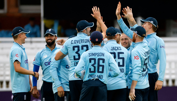 England´s Craig Overton (3rd L) celebrates with teammates after taking the catch on the boundary to dismiss Pakistans Saud Shakeel for 56 off the bowling of Englands Matt Parkinson (3rd R) during the second one day international (ODI) cricket match between England and Pakistan at Lords cricket ground in London on July 10, 2021. Photo: AFP