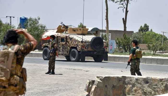 Afghan security personnel stand guard along the road amid ongoing fight between Afghan security forces and Taliban fighters in Kandahar on July 9, 2021. — AFP/Javed Tanveer