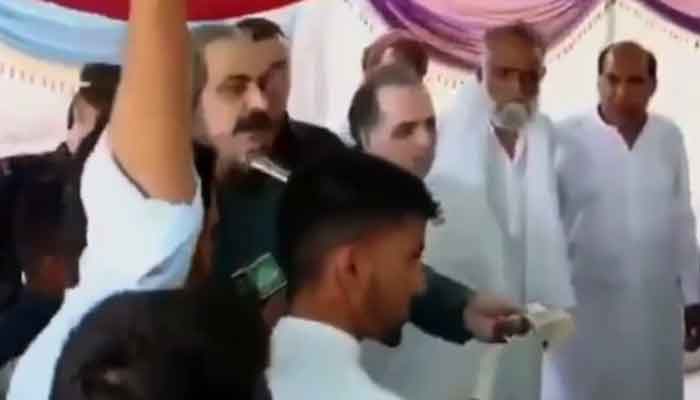 A still from a video circulating on social media showing Federal Minister for Kashmir Affairs and Gilgit-Baltistan Ali Amin Gandapur donating cash to people in Mirpur.