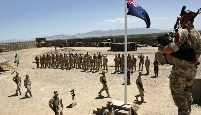 Australian and British troops stand at attention during an ANZAC day ceremony at Camp Armadillo in Afghanistan on April 25, 2008. — Reuters/File
