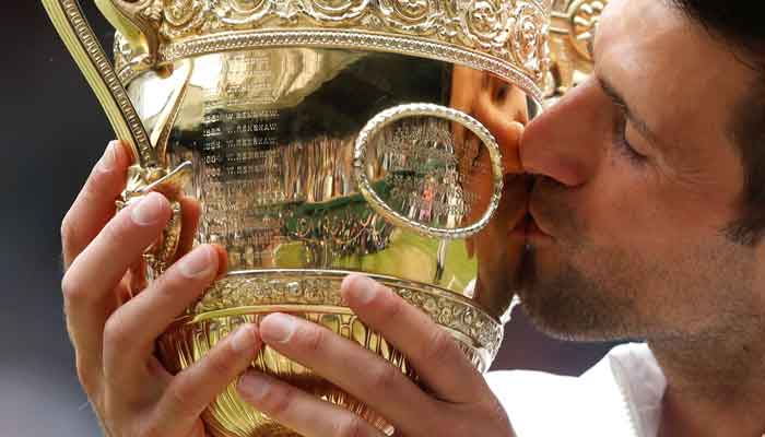 Serbias Novak Djokovic celebrates with the trophy after winning his final match against Italys Matteo Berrettini, Wimbledon, All England Lawn Tennis and Croquet Club, London, Britain , July 11, 2021. — Reuters/Paul Childs