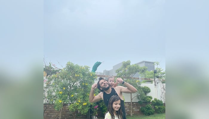 Shahid Afridi can be seen enjoying the first spell of monsoon rains with his daughters in Karachi, on July 12, 2021. — Instagram.