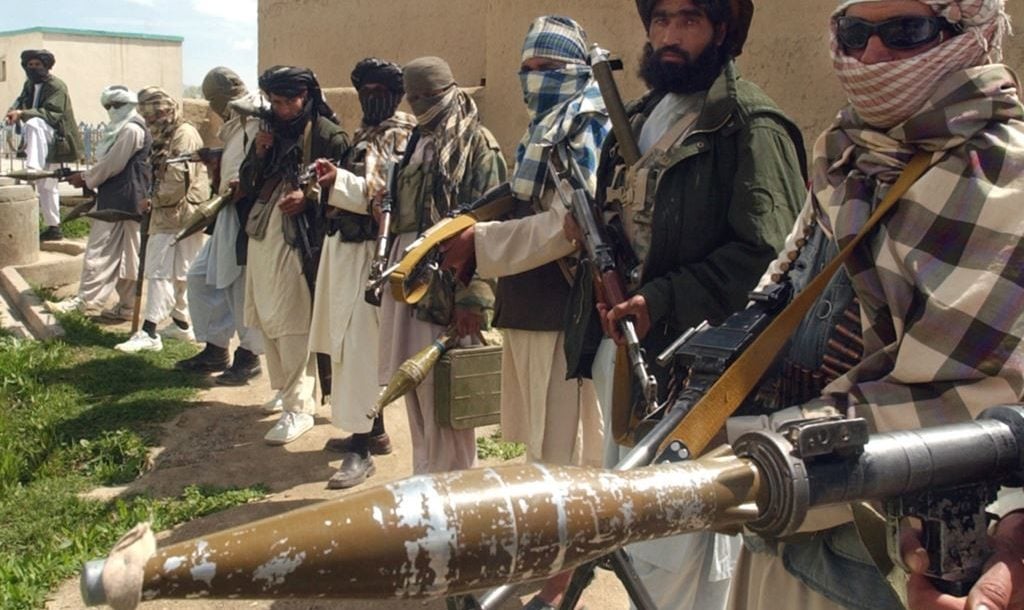 Taliban fighters stand in a line, holding guns and explosives. Photo: AFP