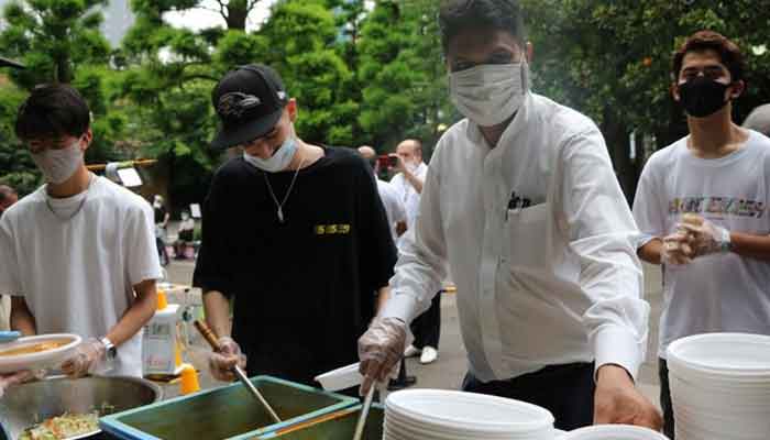 Haroon Qureshi (2nd from R) serves food for homeless people at an event held in Tokyos Ikebukuro district on June 26, 2021. — Photo courtesy Kyodo via APP