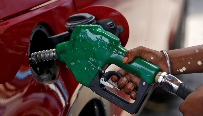 A worker holds a nozzle to pump petrol into a vehicle at a fuel station in Mumbai, India, May 21, 2018. — Reuters/File