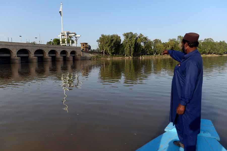 In this photograph taken on March 23, 2021, Ghulam Akbar, a local fisherman and volunteer of the Indus river dolphins rescue team, gestures during a monitoring routine along the Indus river near the southern Sindh province city of Sukkur. — AFP