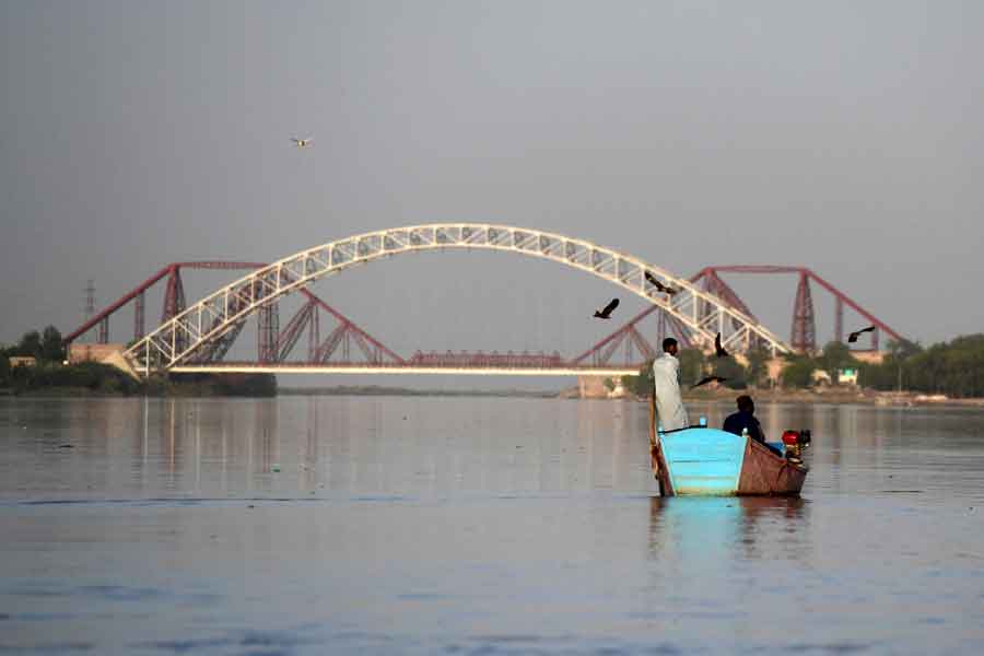 In this photograph taken on March 23, 2021, Ghulam Akbar (R), a local fisherman and volunteer of the Indus river dolphins rescue team, sits on a boat during a monitoring routine along the Indus river near the southern Sindh province city of Sukkur. — AFP