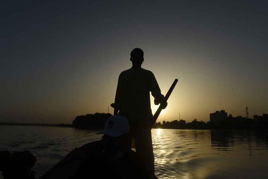 In this photo taken on March 23, 2021, a man is rowing a boat to observe Indus dolphins on a river near Sukkur, a city in southern Sindh. — Agence France-Presse