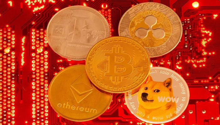 Des représentations de crypto-monnaies Bitcoin, Ethereum, DogeCoin, Ripple, Litecoin sont placées sur la carte mère du PC dans cette illustration prise le 29 juin 2021. Photo : Reuters