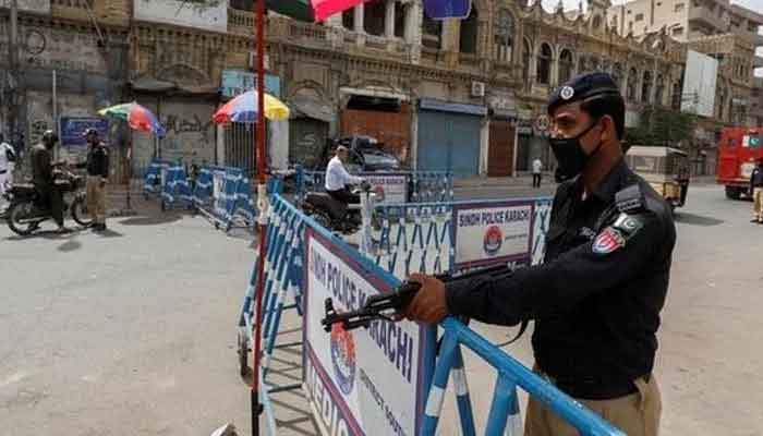 A policeman stands guard beside a barrier as authorities impose a smart lockdown. Photo: File