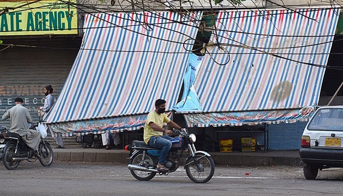 A commuter, wearing a mask to protect him against coronavirus, rides a bike in Karachi. — Geo.tv/Haseem uz Zaman/file