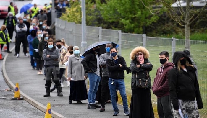 Members of the public queue to receive a Covid-19 vaccine at a temporary clinic at Essa Academy, a school in Bolton, north-west England. Photo: AFP