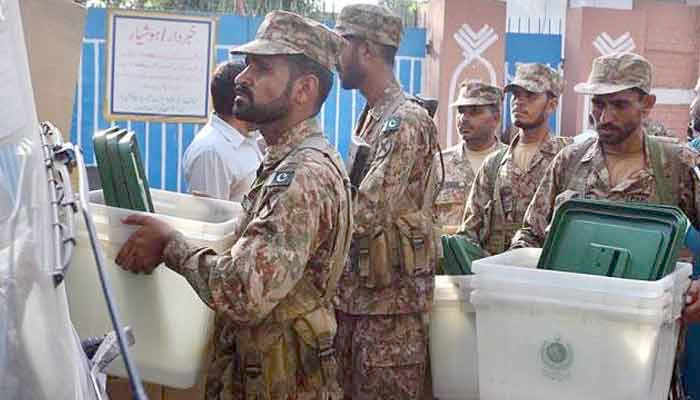 Pakistan Army troops assist in the election process by carrying the ballot boxes. — File photo