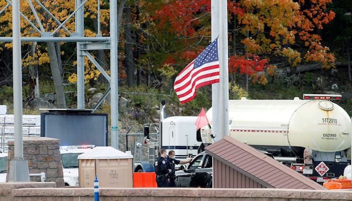 U.S. customs officers speak with a person at the Canada-United States border crossing at the Thousand Islands Bridge, which remains closed to non-essential traffic to combat the spread of the coronavirus disease (COVID-19) in Lansdowne, Ontario, Canada September 28, 2020.