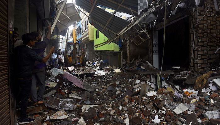 People use their mobile phones to take pictures of a collapsed building following rains in Mumbai, India, July 23, 2021. Photo: Reuters