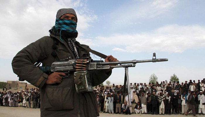 A member of the Taliban and other people stand at the site during the execution of three men in Ghazni Province April 18, 2015. — Reuters/File